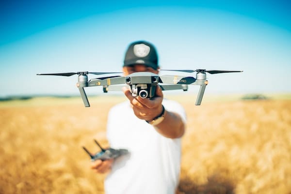 Holding a drone in a paddock on a farm.