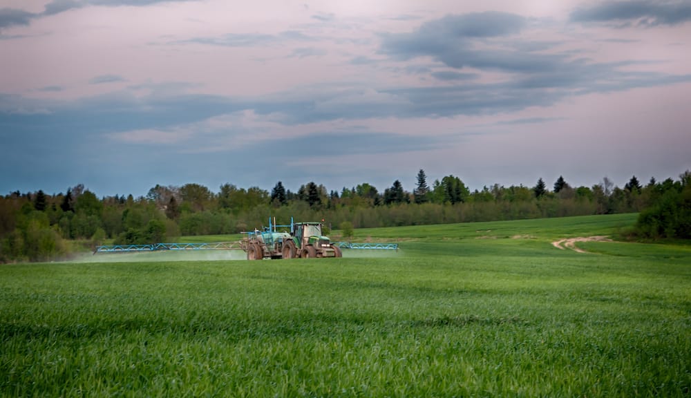 Fungicides being sprayed on pasture with a tractor