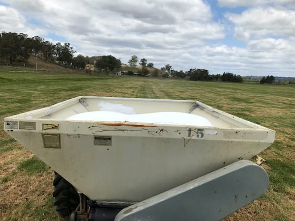 Spreading fertiliser to encourage pasture grow and improved soil conditions.